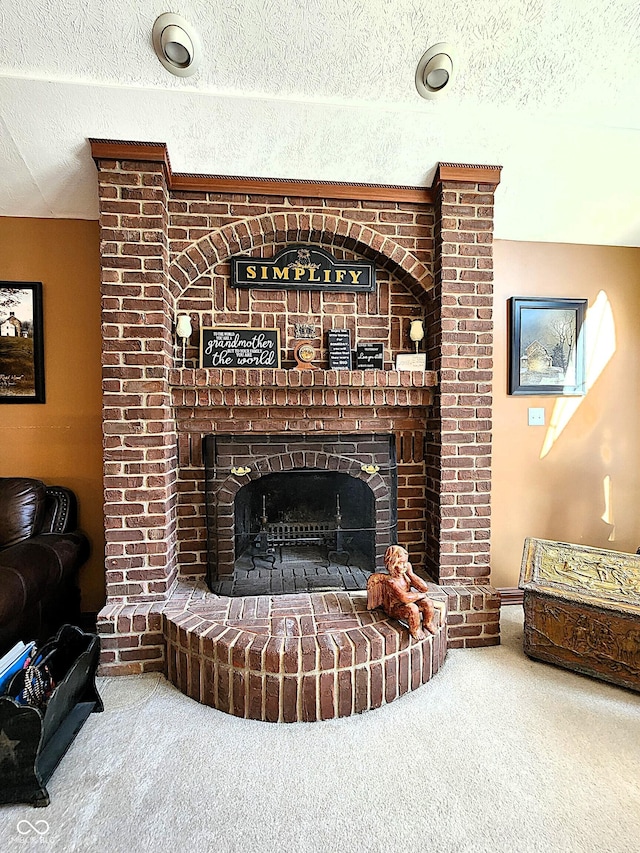 living room featuring carpet floors, a textured ceiling, and a fireplace