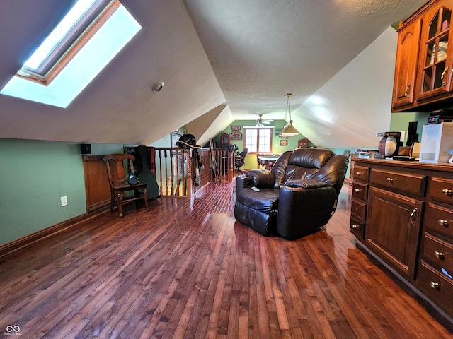 living room featuring vaulted ceiling with skylight, a textured ceiling, and dark wood-style flooring