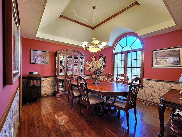 dining space with visible vents, a raised ceiling, wainscoting, and wallpapered walls