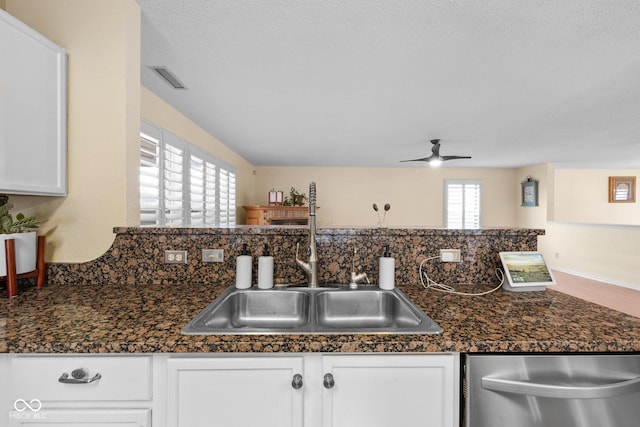 kitchen featuring visible vents, white cabinets, dishwasher, and a sink