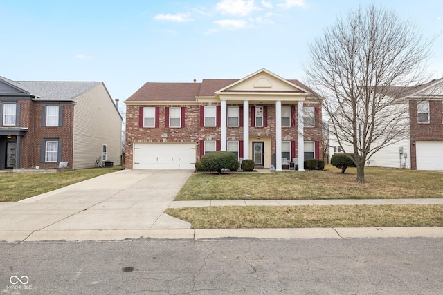 neoclassical / greek revival house featuring a front yard, a garage, brick siding, and driveway