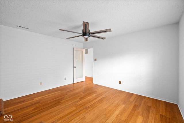 unfurnished room with visible vents, light wood-style flooring, a textured ceiling, and a ceiling fan