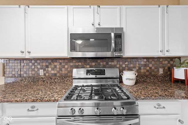 kitchen featuring dark stone countertops, tasteful backsplash, appliances with stainless steel finishes, and white cabinetry