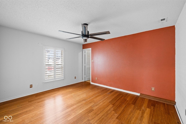 unfurnished room featuring baseboards, a textured ceiling, a ceiling fan, and light wood finished floors