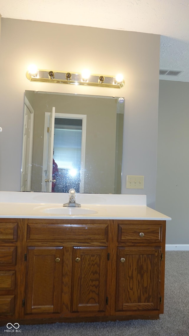 bathroom featuring visible vents, vanity, and a textured ceiling