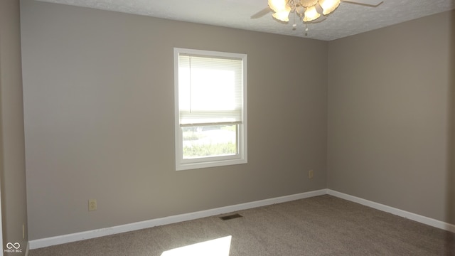 carpeted spare room featuring visible vents, ceiling fan, a textured ceiling, and baseboards