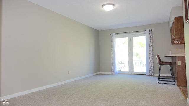 interior space with baseboards and light colored carpet