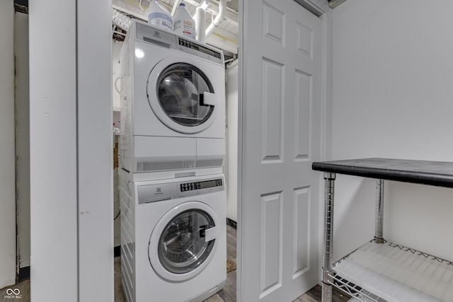 washroom featuring stacked washer and dryer and laundry area