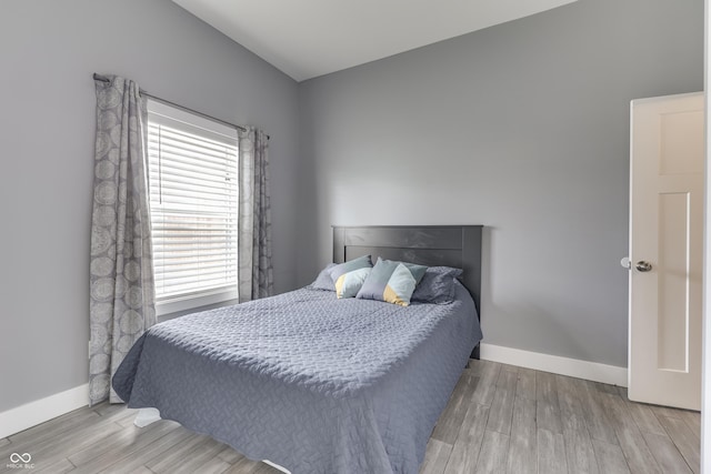 bedroom with baseboards and wood finished floors