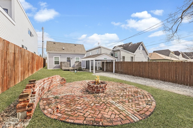 back of property with an outdoor fire pit, a fenced backyard, a lawn, and an outbuilding