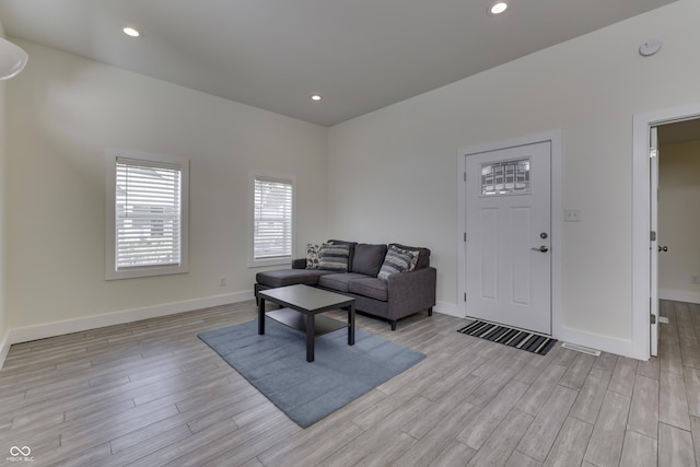 living area with light wood-type flooring, baseboards, and recessed lighting