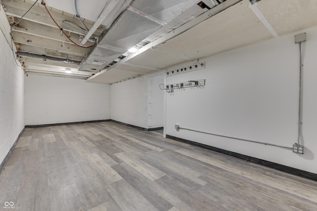 basement with concrete block wall and wood finished floors