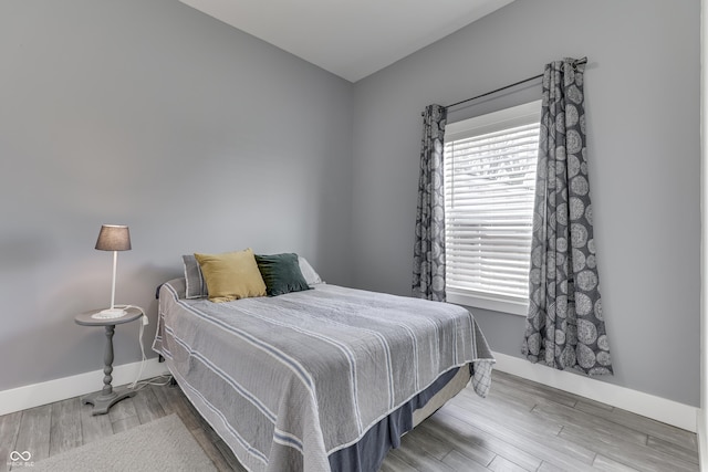 bedroom featuring wood finished floors and baseboards