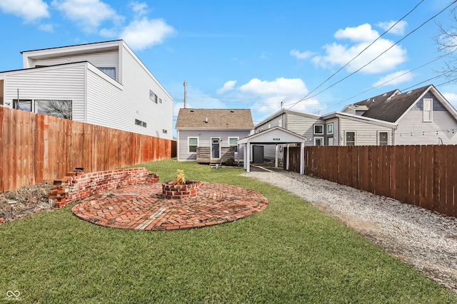 view of yard with a fire pit, a patio, an outbuilding, and a fenced backyard