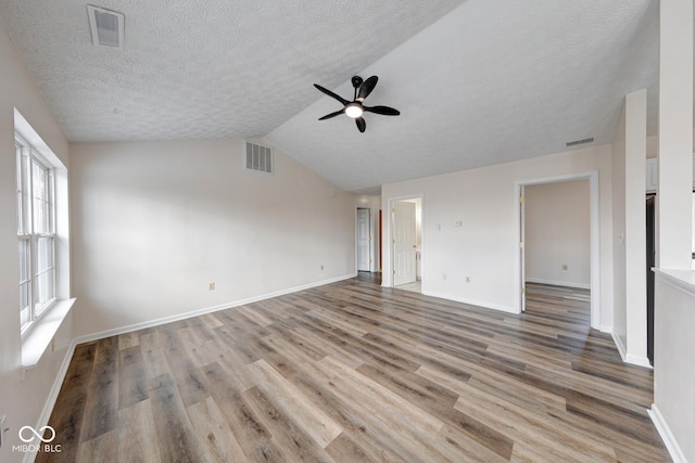 interior space with lofted ceiling, visible vents, and wood finished floors