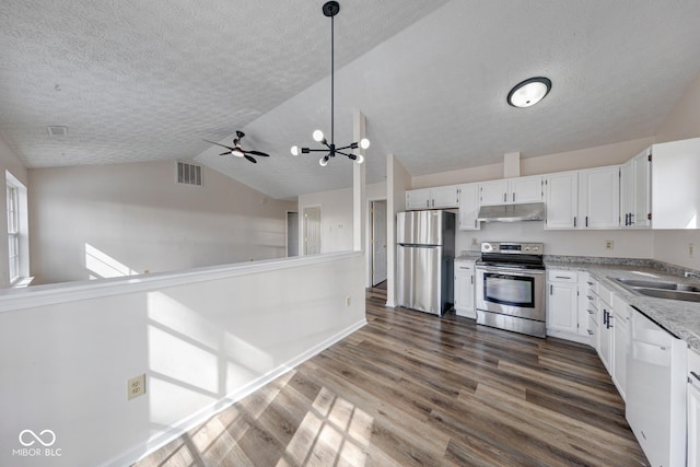 kitchen with dark wood-style flooring, stainless steel appliances, visible vents, a sink, and under cabinet range hood