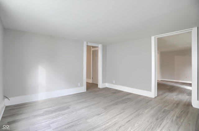 unfurnished room with light wood-style flooring and baseboards