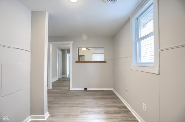 spare room featuring baseboards, light wood-style floors, and ceiling fan