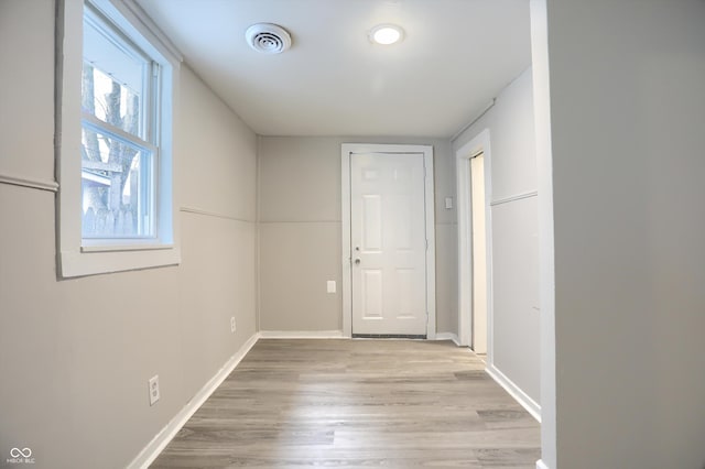 interior space with visible vents, light wood-style flooring, and baseboards