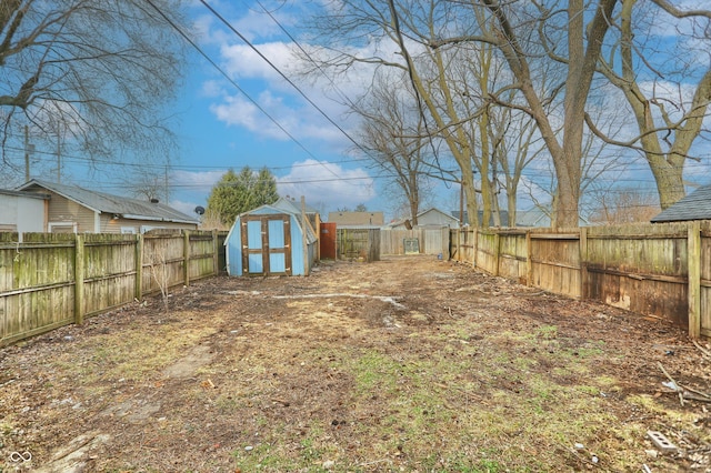 view of yard featuring an outbuilding, a fenced backyard, and a shed