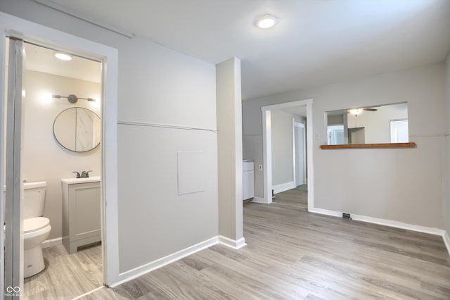 hall with baseboards and light wood-style floors