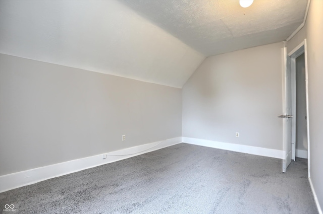 bonus room with baseboards, lofted ceiling, and a textured ceiling