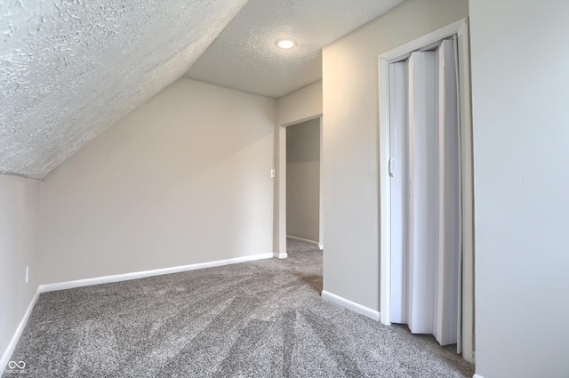 bonus room with vaulted ceiling, a textured ceiling, baseboards, and carpet floors