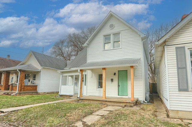 view of front of home with a porch, a shingled roof, and a front lawn