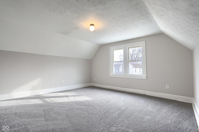 bonus room with baseboards, a textured ceiling, carpet, and lofted ceiling