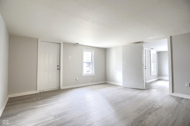 spare room featuring wood finished floors and baseboards