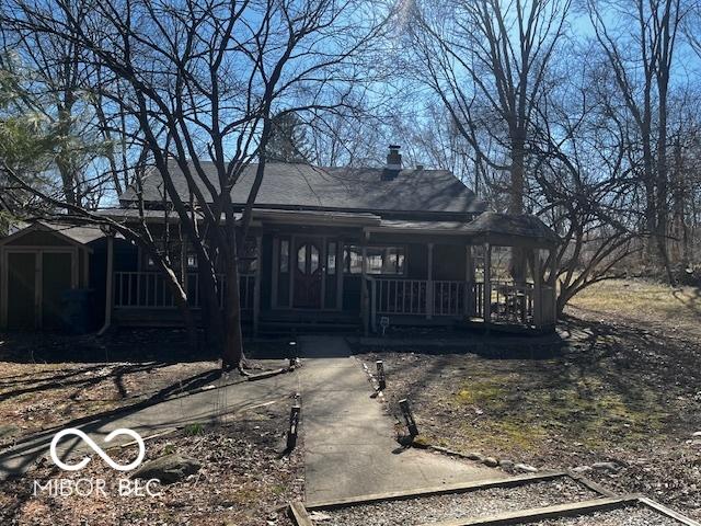 back of property featuring covered porch and a chimney