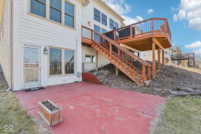 rear view of house with stairs, a patio, and a wooden deck