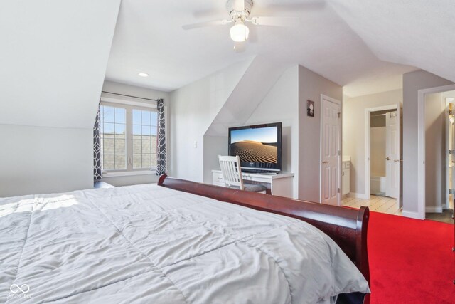 bedroom with vaulted ceiling, a ceiling fan, baseboards, and ensuite bathroom