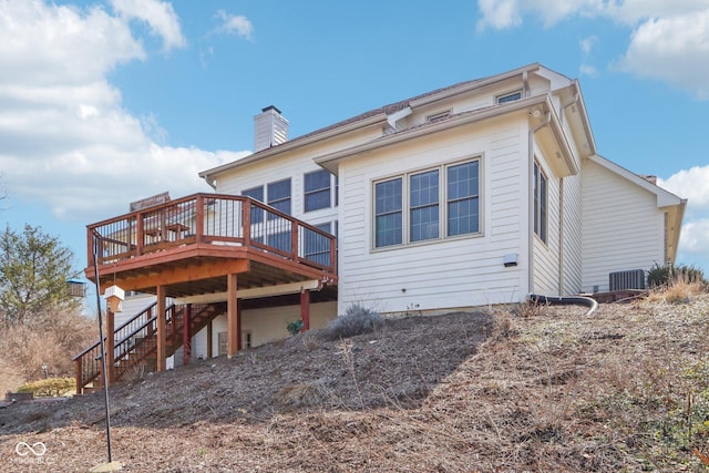 rear view of property featuring stairs, central air condition unit, a deck, and a chimney