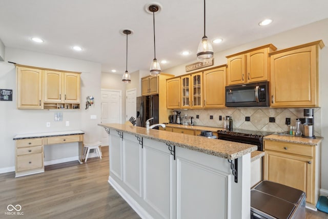 kitchen featuring a kitchen island with sink, dark wood-style flooring, decorative backsplash, and black refrigerator with ice dispenser