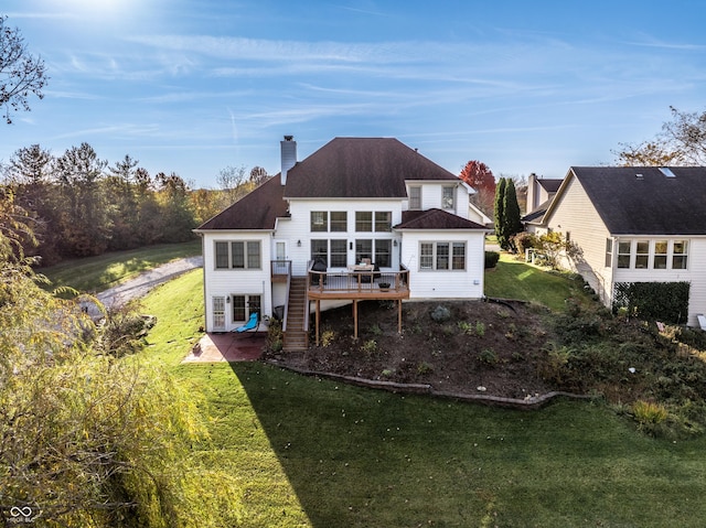 rear view of house featuring stairway, a wooden deck, a yard, a chimney, and a patio area