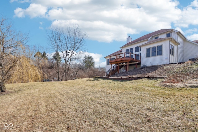 rear view of property featuring a wooden deck, stairway, a chimney, and a yard