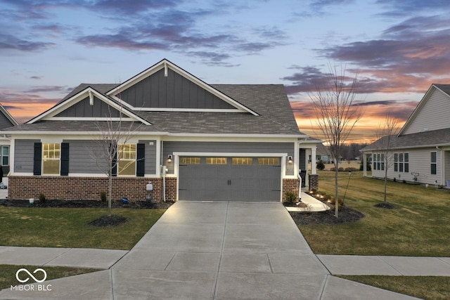 craftsman house featuring an attached garage, brick siding, driveway, a lawn, and board and batten siding