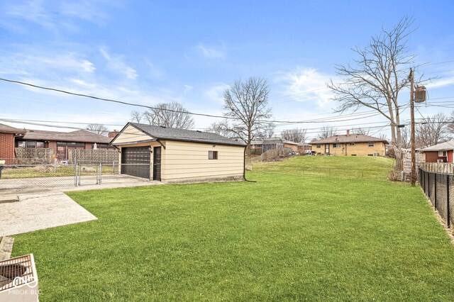 view of yard featuring an outbuilding, a detached garage, and fence