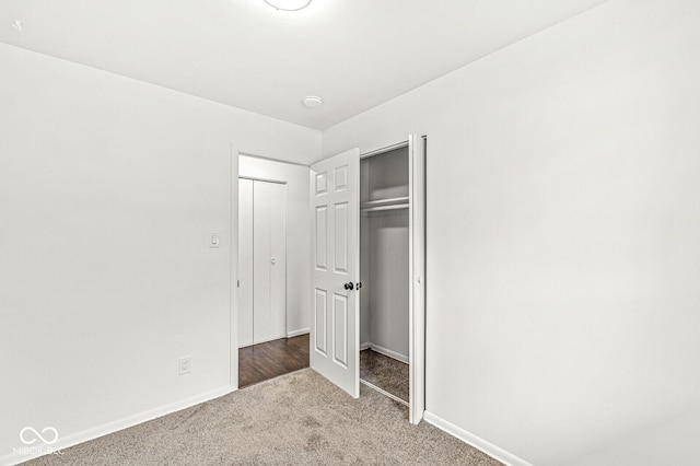 unfurnished bedroom featuring a closet, carpet flooring, and baseboards