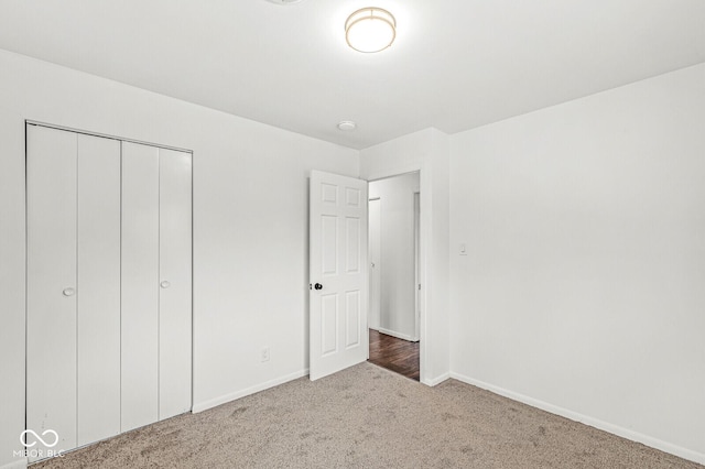 unfurnished bedroom featuring a closet, carpet floors, and baseboards