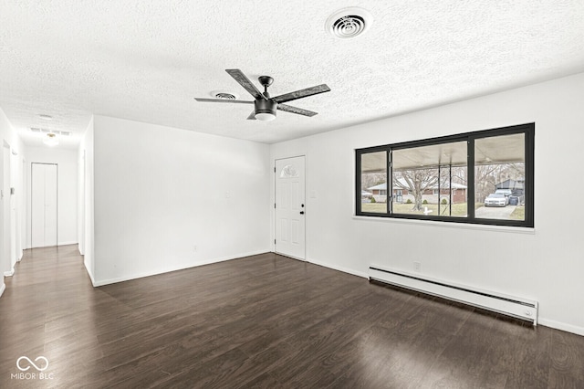 spare room with visible vents, a ceiling fan, a baseboard heating unit, a textured ceiling, and wood finished floors