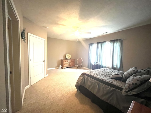 carpeted bedroom with a ceiling fan and baseboards