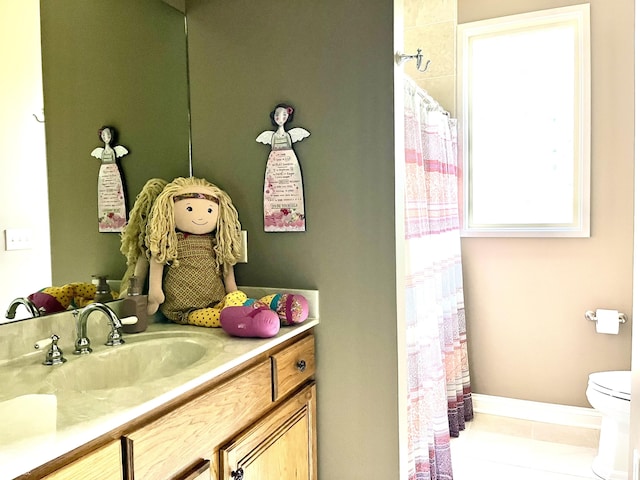 full bathroom featuring toilet, a shower with curtain, baseboards, and vanity