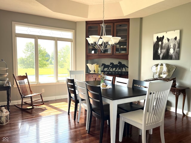 dining space with dark wood-style floors, baseboards, and a chandelier