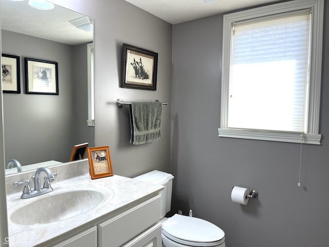 bathroom featuring visible vents, vanity, and toilet