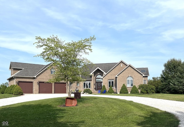 view of front facade with a garage, concrete driveway, brick siding, and a front yard