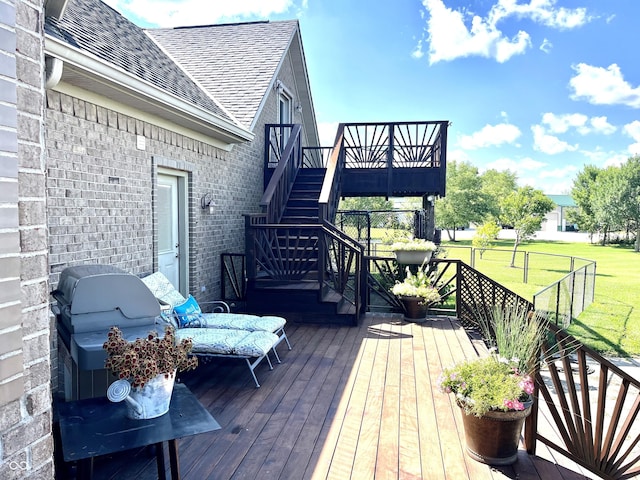 wooden deck featuring a grill, stairs, and a yard