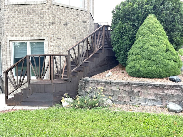 view of property exterior featuring brick siding and stairway