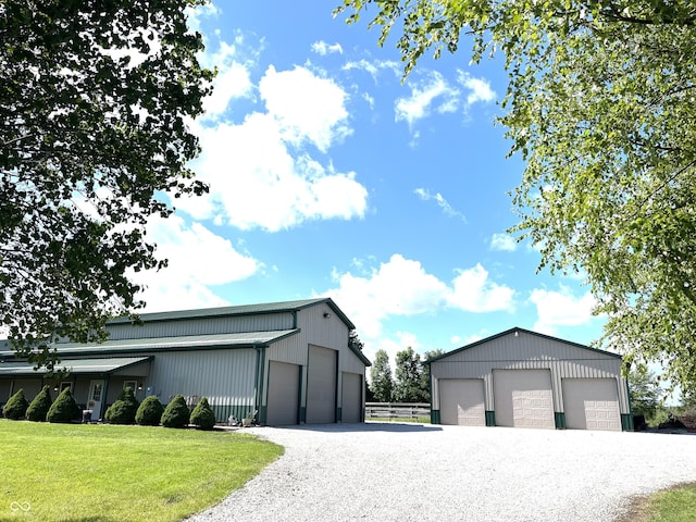 detached garage with gravel driveway and fence